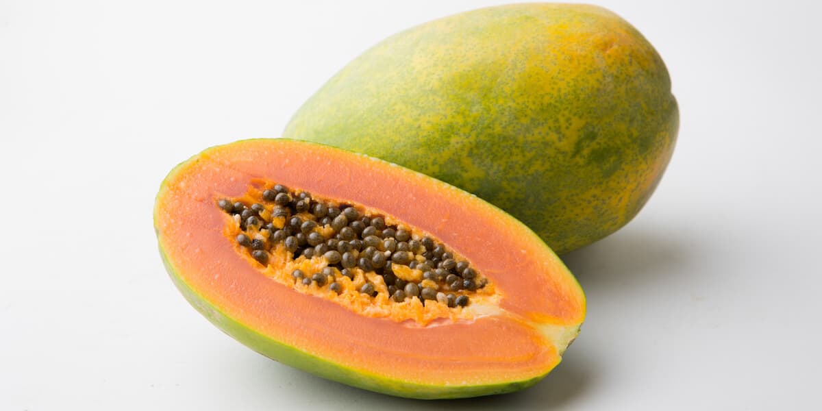 Halved and whole papaya