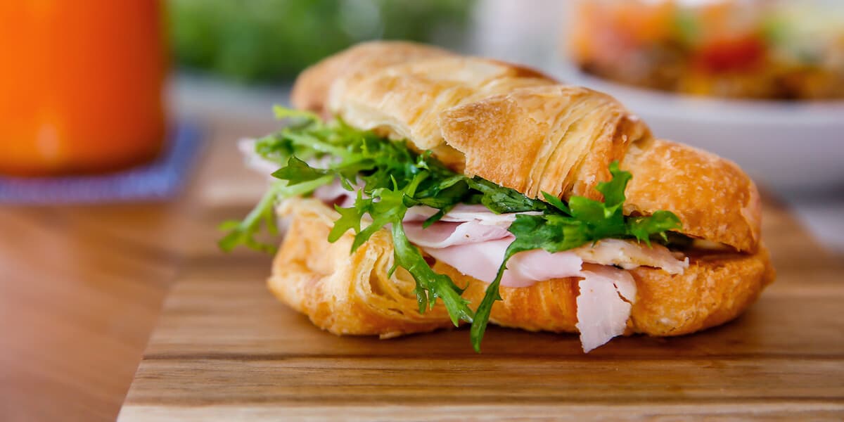 Croissant sandwich with ham and arugula